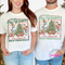 Woman and man smiling while wearing a festive Deck These Halls holiday graphic tee.