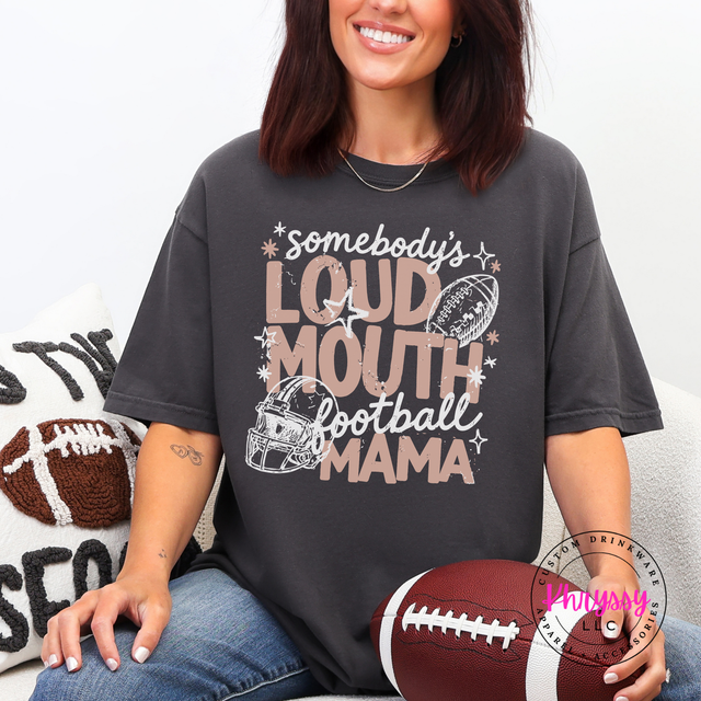 Woman wearing a Comfort Colors tee with bold Somebody's Loud Mouth Football Mama lettering and.