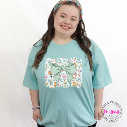 Chalky Mint tee with a sage green bow over watercolor wildflower panels