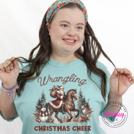 Wrangling Christmas Cheer tee in Chalky Mint featuring Santa on horseback.