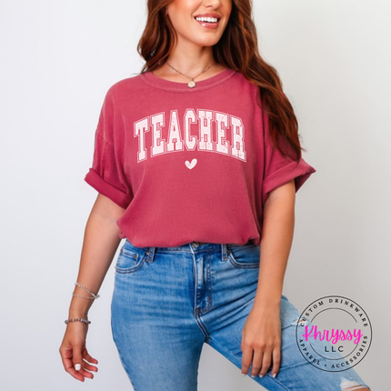 Woman wearing a Crimson Comfort Colors tee with vintage Teacher varsity lettering.