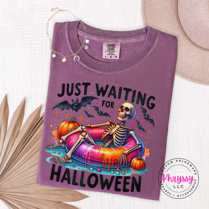 Berry tee featuring a skeleton lounging on a colorful pool float with bats