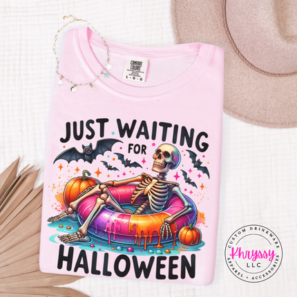 Blossom tee with a Just Waiting for Halloween skeleton on a pool float