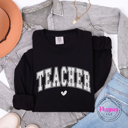 Flat lay of a Black long sleeve tee with a distressed Teacher varsity arch.