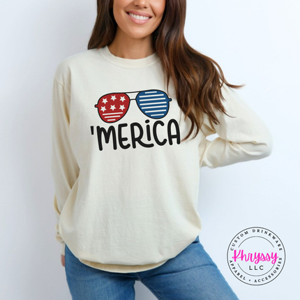 Ivory long sleeve tee featuring flag-print aviator sunglasses and 'Merica lettering.