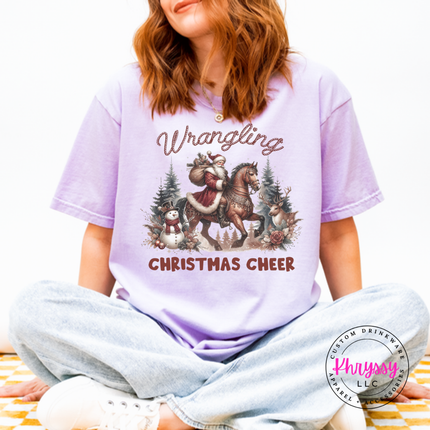 Wrangling Christmas Cheer tee in Orchid featuring Santa on horseback.