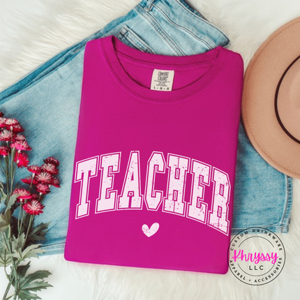 Flat lay of a Boysenberry teacher varsity long sleeve tee with a heart graphic.