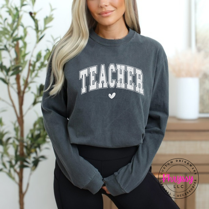 Woman wearing a Pepper long sleeve tee with a distressed Teacher varsity arch.