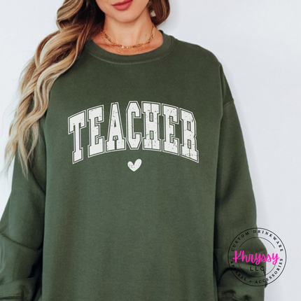 Woman wearing a Military Green crewneck sweatshirt with vintage Teacher varsity lettering.
