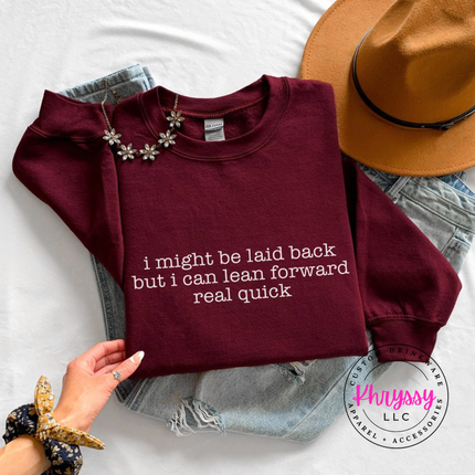 Maroon crewneck sweatshirt with white typewriter quote about being laid back but leaning forward.