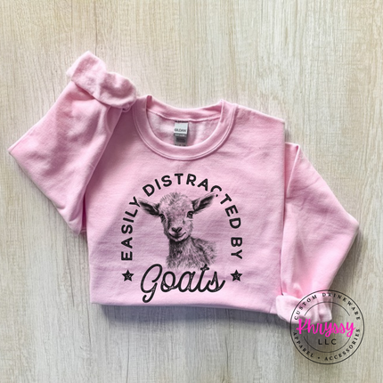 Light Pink crewneck sweatshirt with Easily Distracted by Goats print and sketched baby goat.