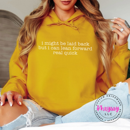 Gold hoodie with white typewriter quote about being laid back but leaning forward.