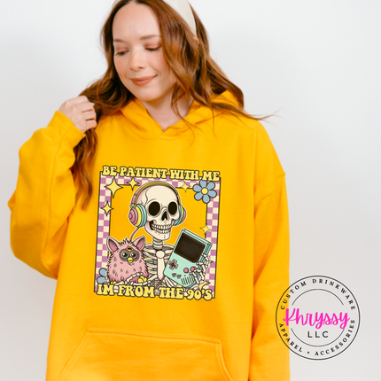 Gold hoodie showing a laid-back skeleton in front of a striped retro sunset.