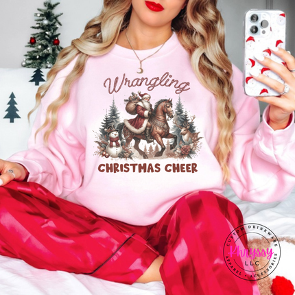 Wrangling Christmas Cheer crewneck sweatshirt in Light Pink featuring Santa on horseback.