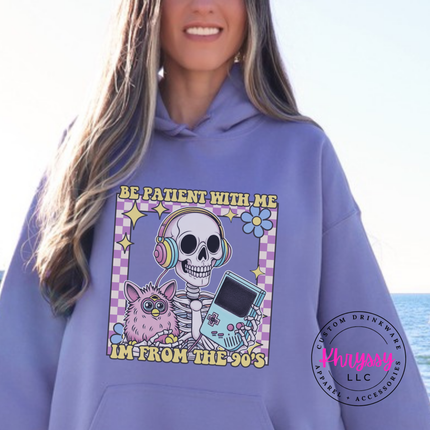 Violet hoodie showing a laid-back skeleton in front of a striped retro sunset.