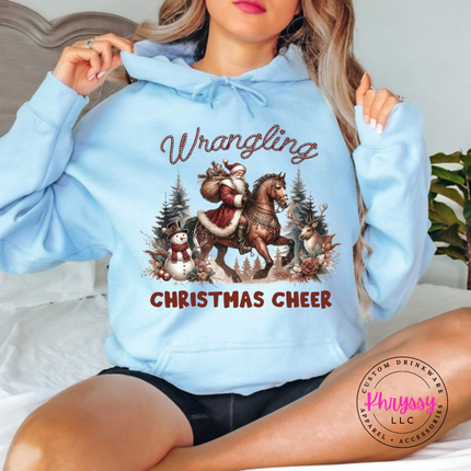 Wrangling Christmas Cheer hoodie in Light Blue featuring Santa on horseback.