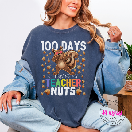Dabbing squirrel graphic shown on a denim colored tee with acorns.