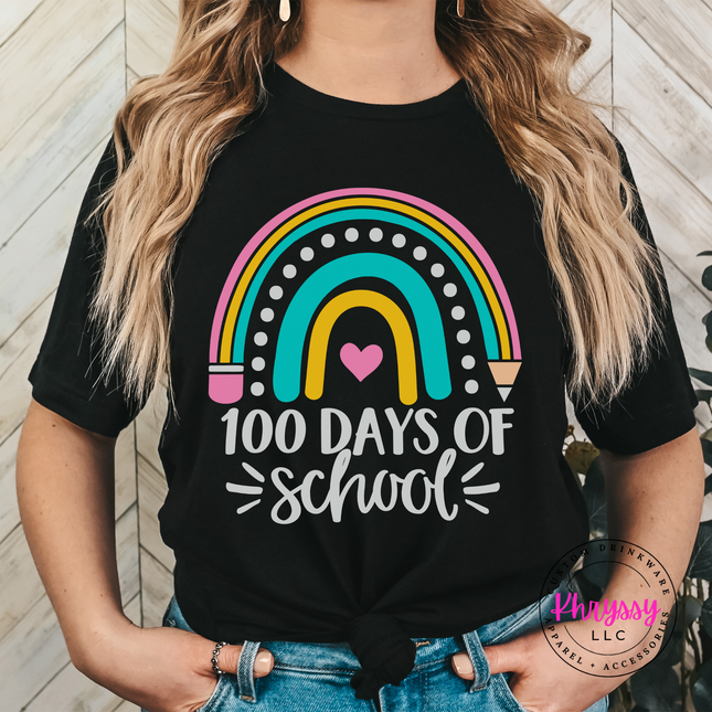 Woman wearing a black 100 Days Of School rainbow graphic tee outdoors.