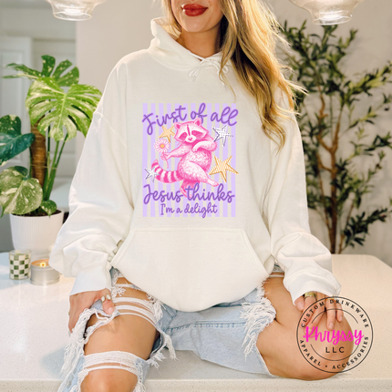 Person wearing a white hoodie with a graphic design and text, sitting in a room with plants.
