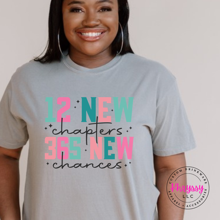 Gray tee showing colorful New Year lettering and black script.