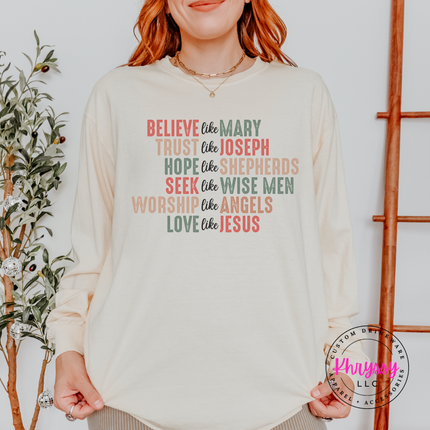 Ivory long sleeve tee featuring Believe Like Mary nativity lettering.