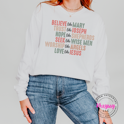 Flat lay of the Believe Like Mary Christmas long sleeve tee in White.