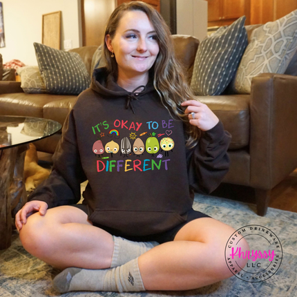 Bold colorful inclusion teacher hoodie on dark chocolate Gildan with vibrant rainbow character and bright classroom detail