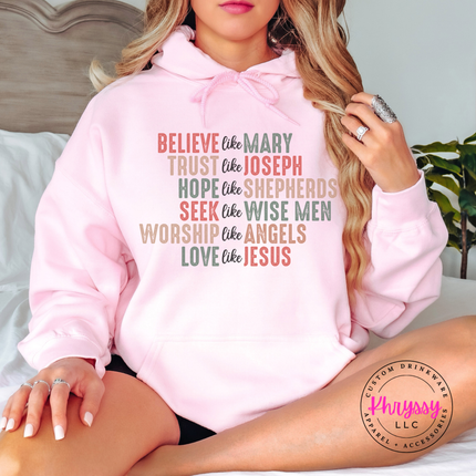 Flat lay of the Believe Like Mary Christmas hoodie in Light Pink.