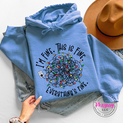 Woman wearing the I'm Fine This Is Fine Christmas hoodie in Carolina Blue.