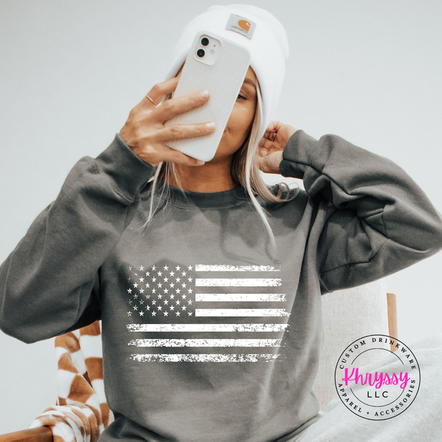 Charcoal crewneck sweatshirt with a white distressed American flag graphic on the chest.