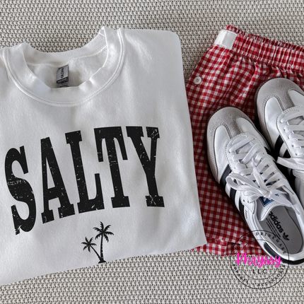 White crewneck sweatshirt displaying a black distressed SALTY beach graphic.