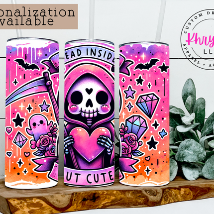 Cute and colorful tumblers with skull designs on a wooden surface with plants.