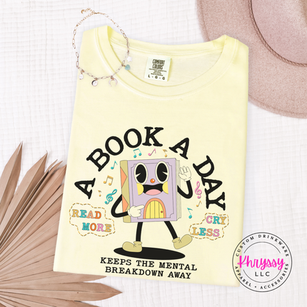 Butter Comfort Colors tee with retro cartoon book character A Book A Day Keeps The Mental Breakdown Away print.