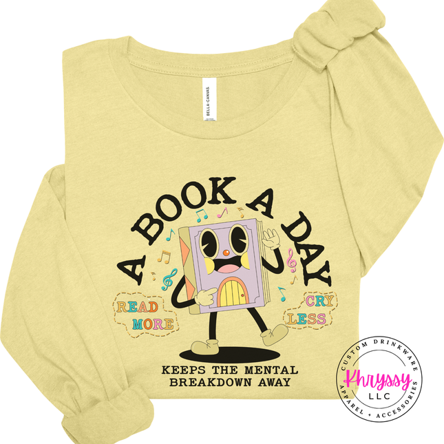 Heather French Vanilla long sleeve featuring the pastel lavender book character and A Book A Day lettering.