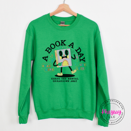 Irish Green Gildan hoodie printed with the retro cartoon A Book A Day Keeps The Mental Breakdown Away graphic.