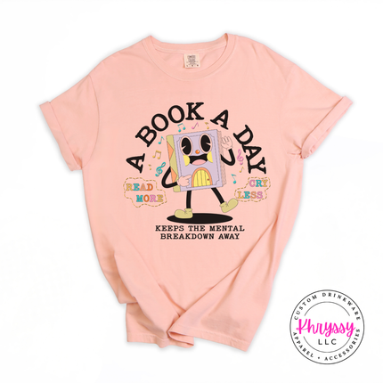 Peachy Comfort Colors tee with the warm retro cartoon book character A Book A Day mental breakdown away print.