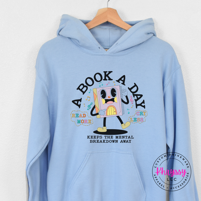Light blue Gildan hoodie showing the multicolor retro book character and mental breakdown away text.