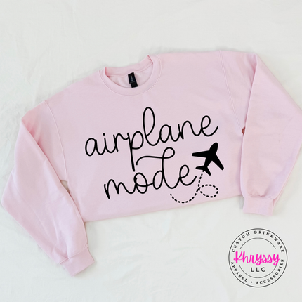Light pink crewneck sweatshirt displaying a black airplane mode script and plane graphic.