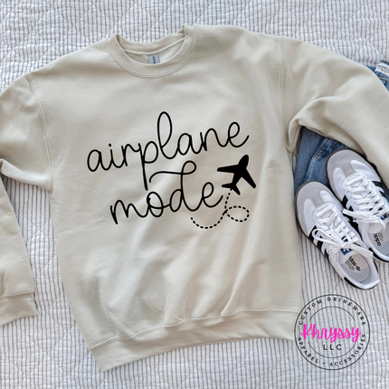 Sand crewneck sweatshirt displaying a black airplane mode script and plane graphic.