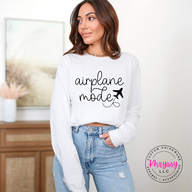 White long sleeve tee displaying a black airplane mode script and plane graphic.
