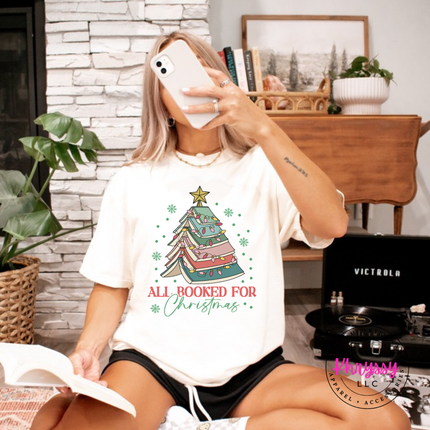 Model wearing the All Booked For Christmas book tree tee in Ivory.