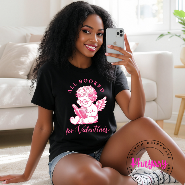 Woman wearing a black t-shirt with a graphic design, sitting on the floor in a living room.