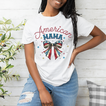White garment-dyed tee displaying a vintage patriotic American Mama bow graphic.