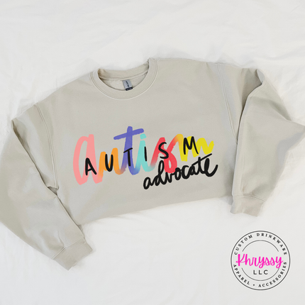 Autism advocate crewneck in Sand, layered for a cool day.