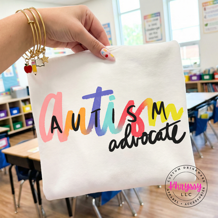 Woman wearing a White autism advocate tee with colorful rainbow script.