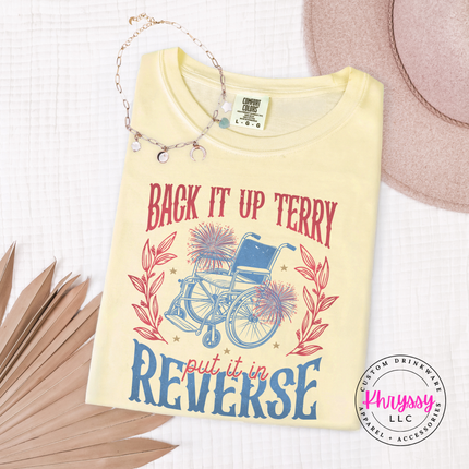 Folded yellow t-shirt with a wheelchair graphic and text on a textured surface.