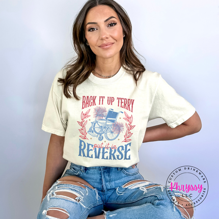 Woman wearing an ivory t-shirt with a graphic design and text, sitting against a light gray background.