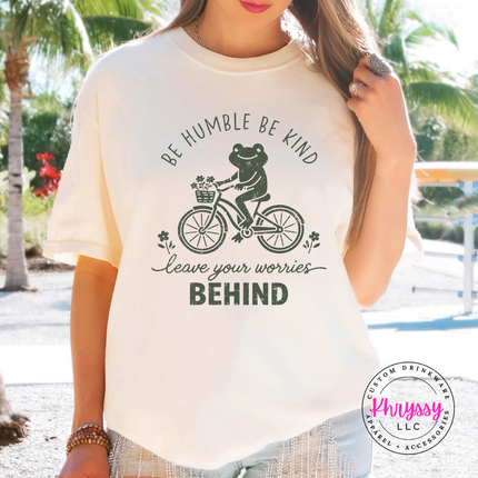 Ivory tee with the be humble be kind frog bicycle design in black or green