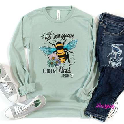 Mint green long-sleeve shirt with bee graphic and text, paired with jeans and sneakers on a white background.