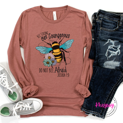 Mauve long-sleeve shirt with bee graphic and text, paired with jeans and sneakers on a white background.